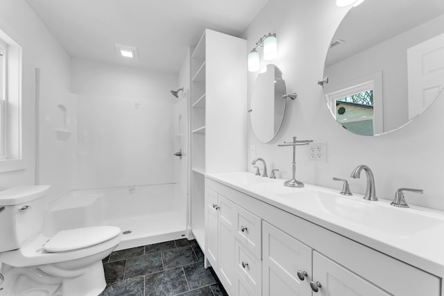 full bath with toilet, double vanity, a sink, and a shower stall