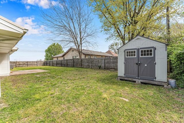 view of yard with an outbuilding, a shed, and a fenced backyard