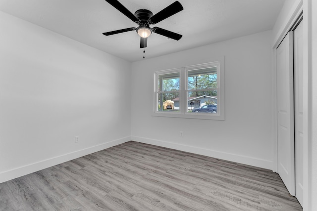 unfurnished bedroom featuring baseboards, a closet, and wood finished floors