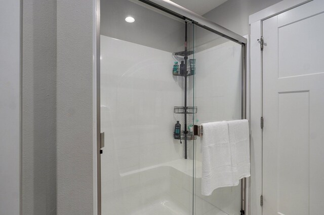 bathroom with recessed lighting and a shower stall