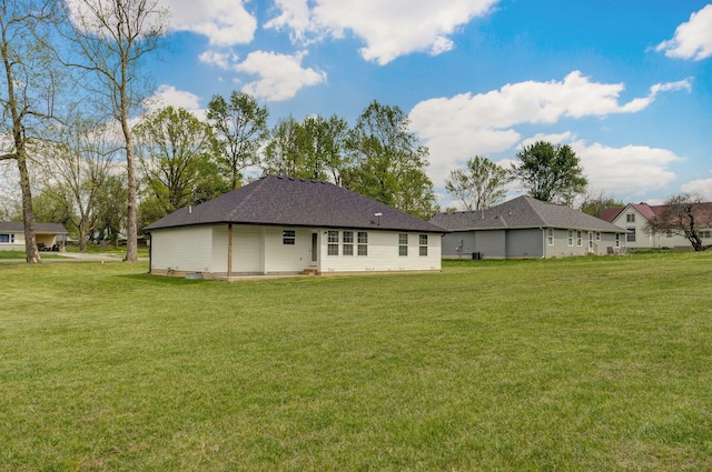 rear view of house featuring a lawn