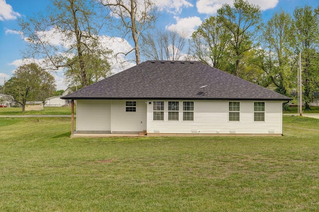 rear view of property with roof with shingles and a yard