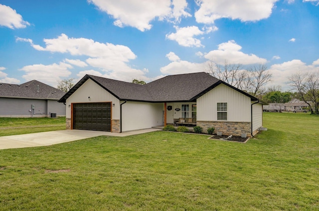 view of front of home with a shingled roof, a garage, stone siding, a front lawn, and concrete driveway