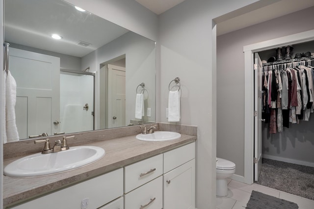 full bathroom with double vanity, a shower stall, toilet, and a sink
