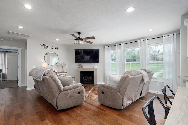 living room featuring recessed lighting, wood finished floors, visible vents, a ceiling fan, and baseboards