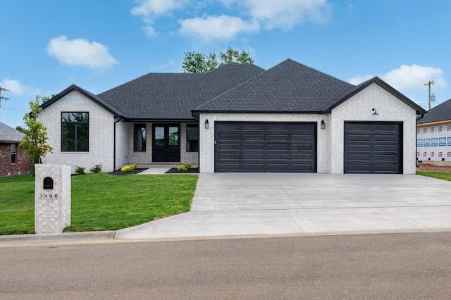 3800 W Broadmoor St, Springfield, MO 65807 - view of front of home featuring a garage, driveway, a front lawn, brick siding, and a shingled roof