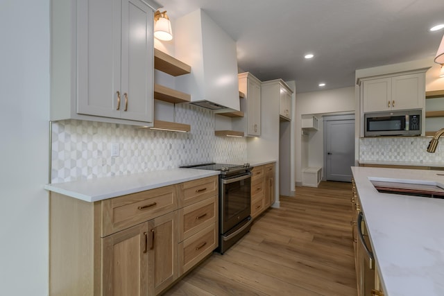 3800 W Broadmoor St, Springfield, MO 65807 - kitchen featuring appliances with stainless steel finishes, open shelves, light countertops, light wood finished floors, and backsplash
