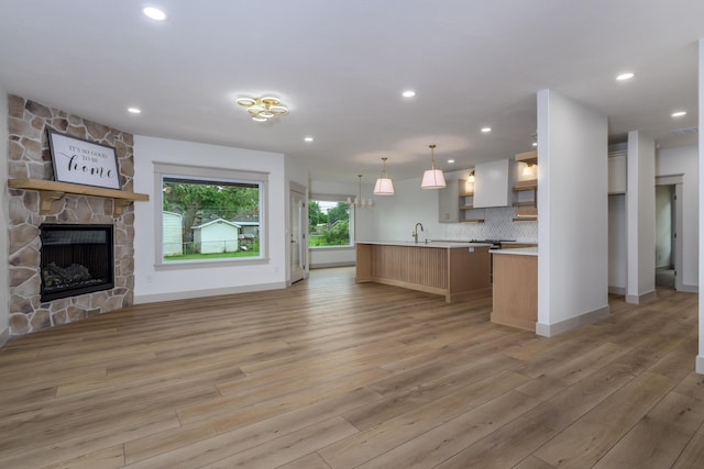 3800 W Broadmoor St, Springfield, MO 65807 - kitchen featuring open floor plan, light countertops, light wood finished floors, open shelves, and a fireplace