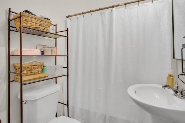 full bathroom with toilet, a shower with curtain, and a sink