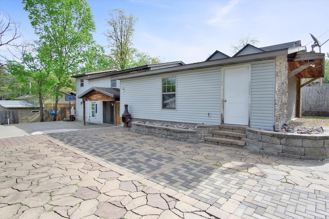 view of front of home with a patio, fence, and entry steps