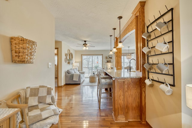 50 Tall Tree Dr, Strafford, MO 65757 - interior space with a ceiling fan, wood-type flooring, light stone countertops, a textured ceiling, and open floor plan