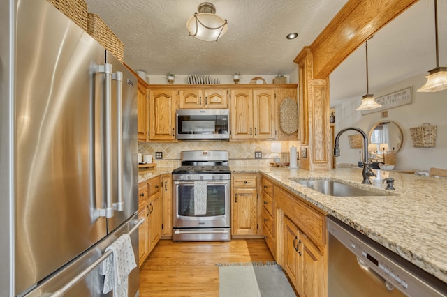 50 Tall Tree Dr, Strafford, MO 65757 - kitchen with a sink, stainless steel appliances, light wood-style flooring, backsplash, and light stone countertops