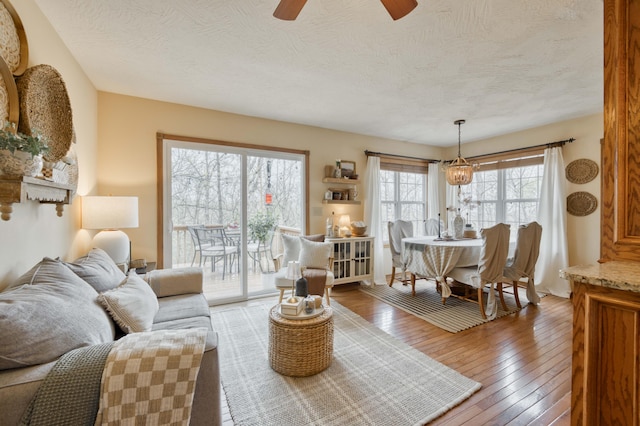 50 Tall Tree Dr, Strafford, MO 65757 - living room featuring hardwood / wood-style flooring, a textured ceiling, and ceiling fan with notable chandelier