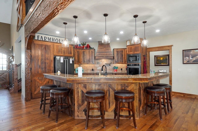 231 Cedar Stone, Ozark, MO 65721 - kitchen with brown cabinets, dark wood finished floors, stainless steel appliances, premium range hood, and tasteful backsplash