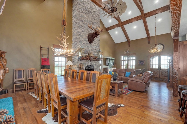 231 Cedar Stone, Ozark, MO 65721 - dining area with high vaulted ceiling, a stone fireplace, light wood-style floors, an inviting chandelier, and beamed ceiling