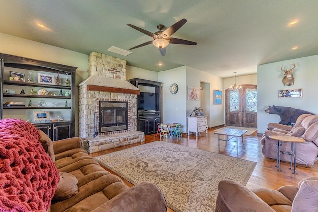 19800 Providence Dr, Lebanon, MO 65536 - living area featuring a stone fireplace, wood finished floors, ceiling fan with notable chandelier, visible vents, and recessed lighting