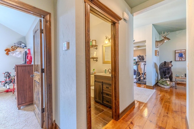 19800 Providence Dr, Lebanon, MO 65536 - hall with baseboards, a textured wall, a sink, and light wood-style floors