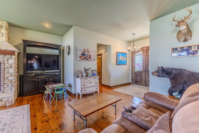 19800 Providence Dr, Lebanon, MO 65536 - living room with hardwood / wood-style floors, a fireplace with raised hearth, baseboards, and an inviting chandelier
