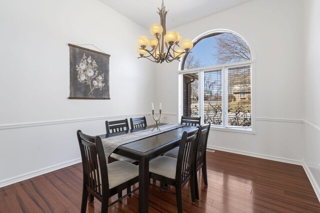 dining space featuring baseboards, wood finished floors, and a chandelier