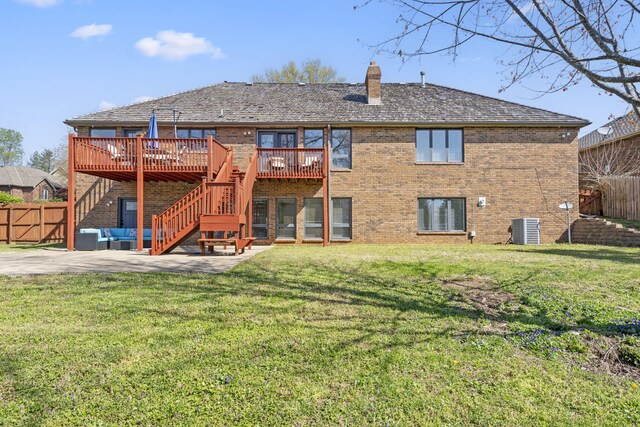 back of house featuring an outdoor living space, a chimney, a patio, a wooden deck, and brick siding