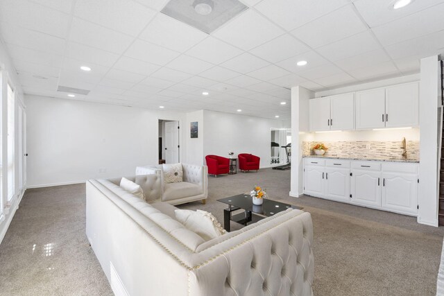 living area with light carpet, baseboards, recessed lighting, and a drop ceiling