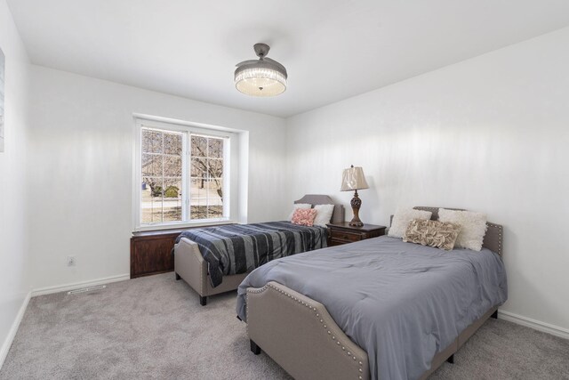 carpeted bedroom with visible vents and baseboards