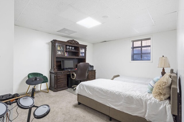 bedroom featuring carpet flooring and a drop ceiling