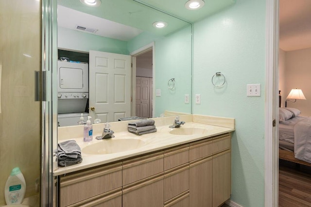 720 Fall Creek Dr Unit 3, Branson, MO 65616 - ensuite bathroom featuring stacked washing machine and dryer, double vanity, wood finished floors, and recessed lighting