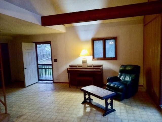 sitting room featuring tile patterned floors, baseboards, and beam ceiling