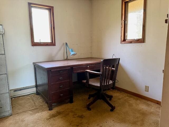 office space with baseboard heating, carpet floors, and baseboards