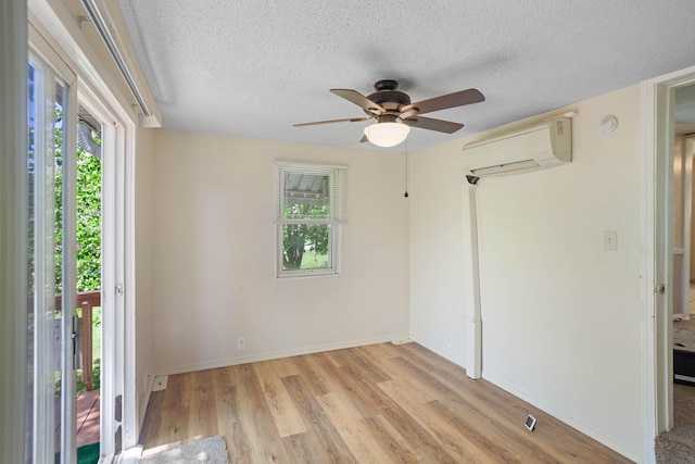 295 Glendale St, Rockaway Beach, MO 65740 - unfurnished bedroom featuring wood finished floors, a wall mounted air conditioner, baseboards, a ceiling fan, and a textured ceiling