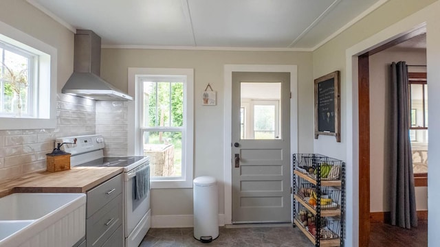 kitchen with decorative backsplash, white electric stove, gray cabinets, wall chimney exhaust hood, and baseboards