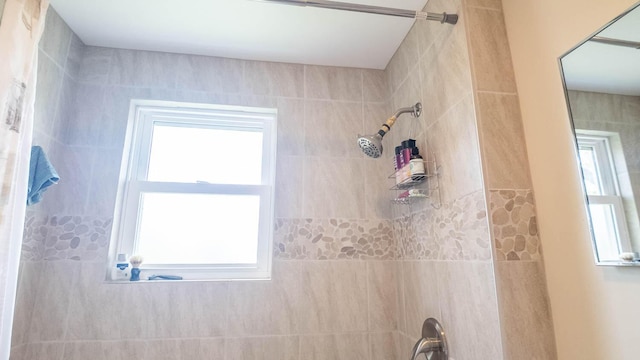 bathroom featuring a wealth of natural light and tiled shower