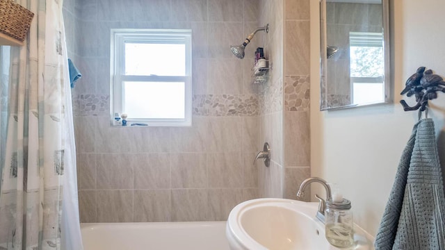 bathroom featuring shower / bath combination with curtain and a sink