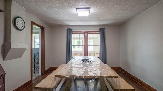 dining room featuring baseboards and dark wood-type flooring