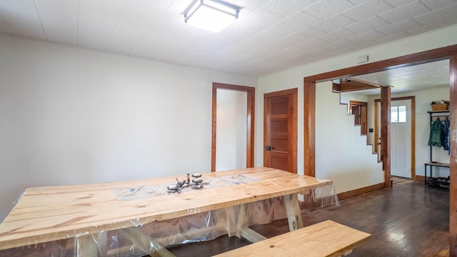dining room with stairway, dark wood-style floors, and baseboards