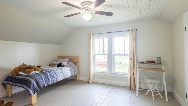 bedroom with baseboards, ceiling fan, lofted ceiling, and wood-type flooring