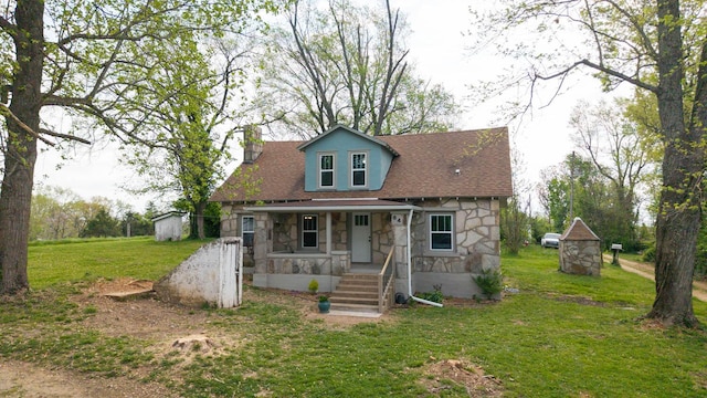 bungalow-style house featuring covered porch, a storage shed, a chimney, and stone siding
