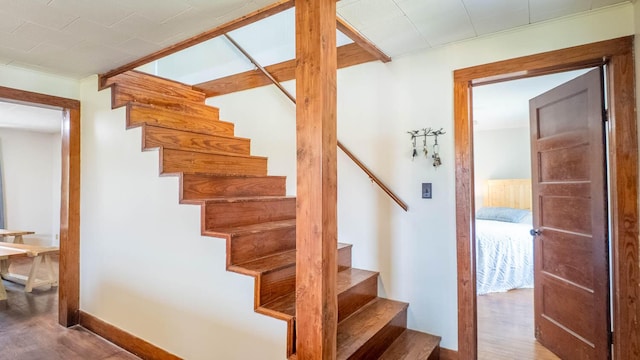 stairway with baseboards and wood finished floors