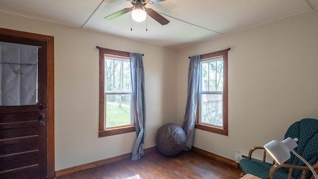 unfurnished room featuring wood finished floors, a ceiling fan, and baseboards