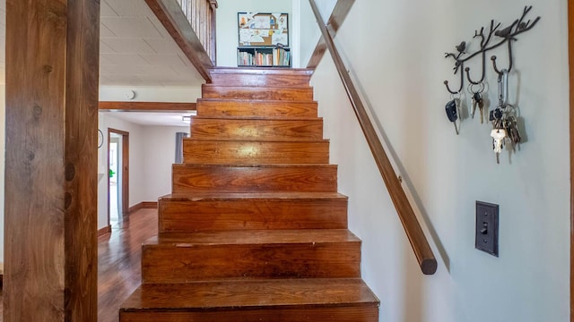 stairs featuring wood finished floors and baseboards