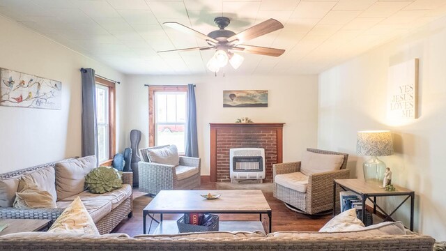 living room featuring wood finished floors, a ceiling fan, and a fireplace