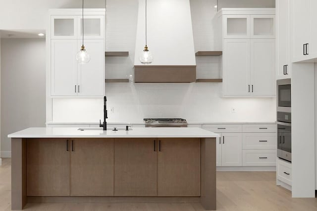 5913 S Clay Ave, Springfield, MO 65810 - kitchen with white cabinetry, a sink, appliances with stainless steel finishes, light countertops, and a kitchen island with sink