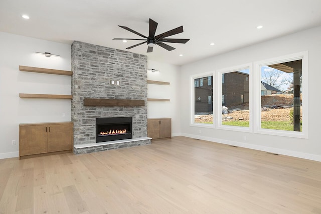 5913 S Clay Ave, Springfield, MO 65810 - unfurnished living room featuring wood finished floors, a stone fireplace, baseboards, visible vents, and a ceiling fan