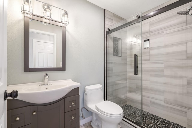 bathroom featuring vanity, toilet, and a shower stall