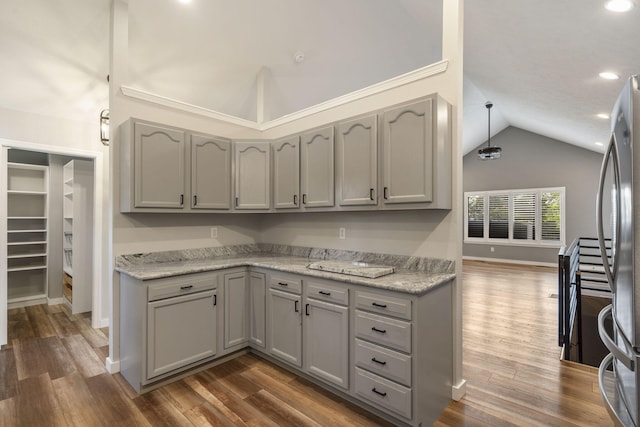 kitchen with dark wood-type flooring, freestanding refrigerator, gray cabinets, and lofted ceiling