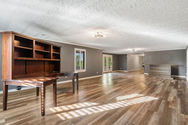 unfurnished office with baseboards, a textured ceiling, and wood finished floors