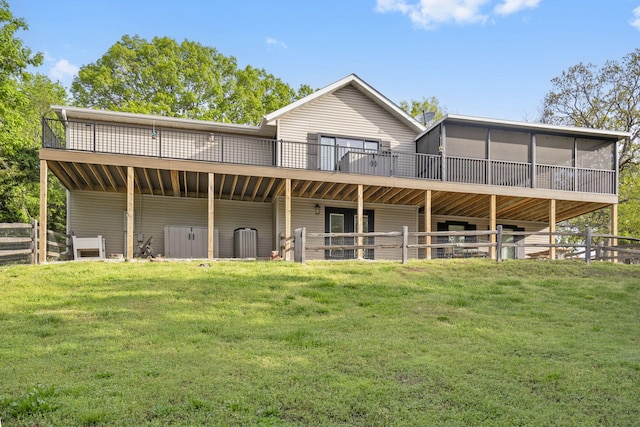 back of property featuring a lawn and a deck