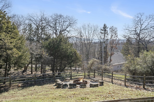 view of yard with fence and an outdoor fire pit