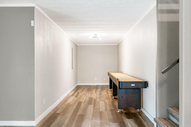 hallway featuring crown molding, stairs, baseboards, and wood finished floors
